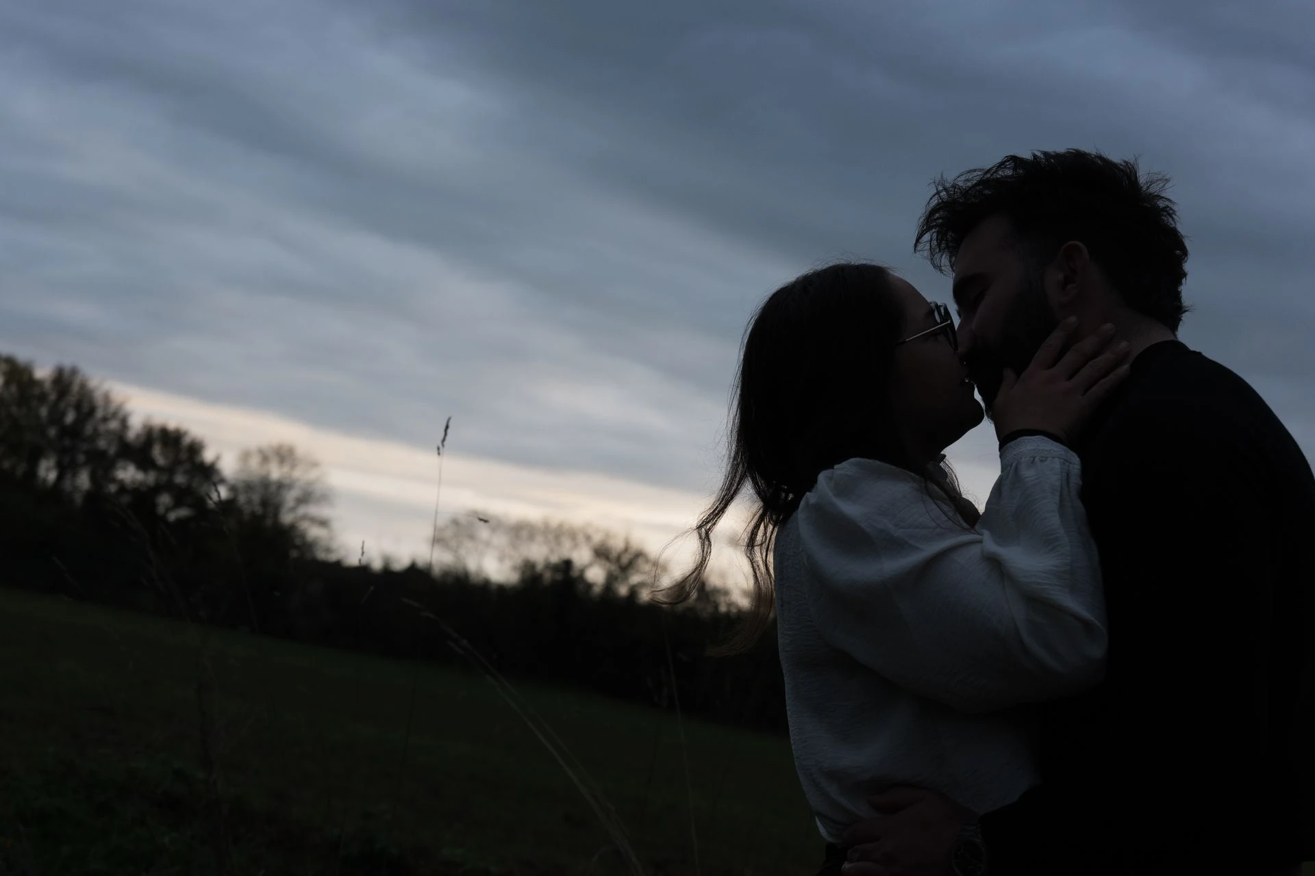Un jeune couple qui s'embrasse sur un champ. Une déclaration d'amour